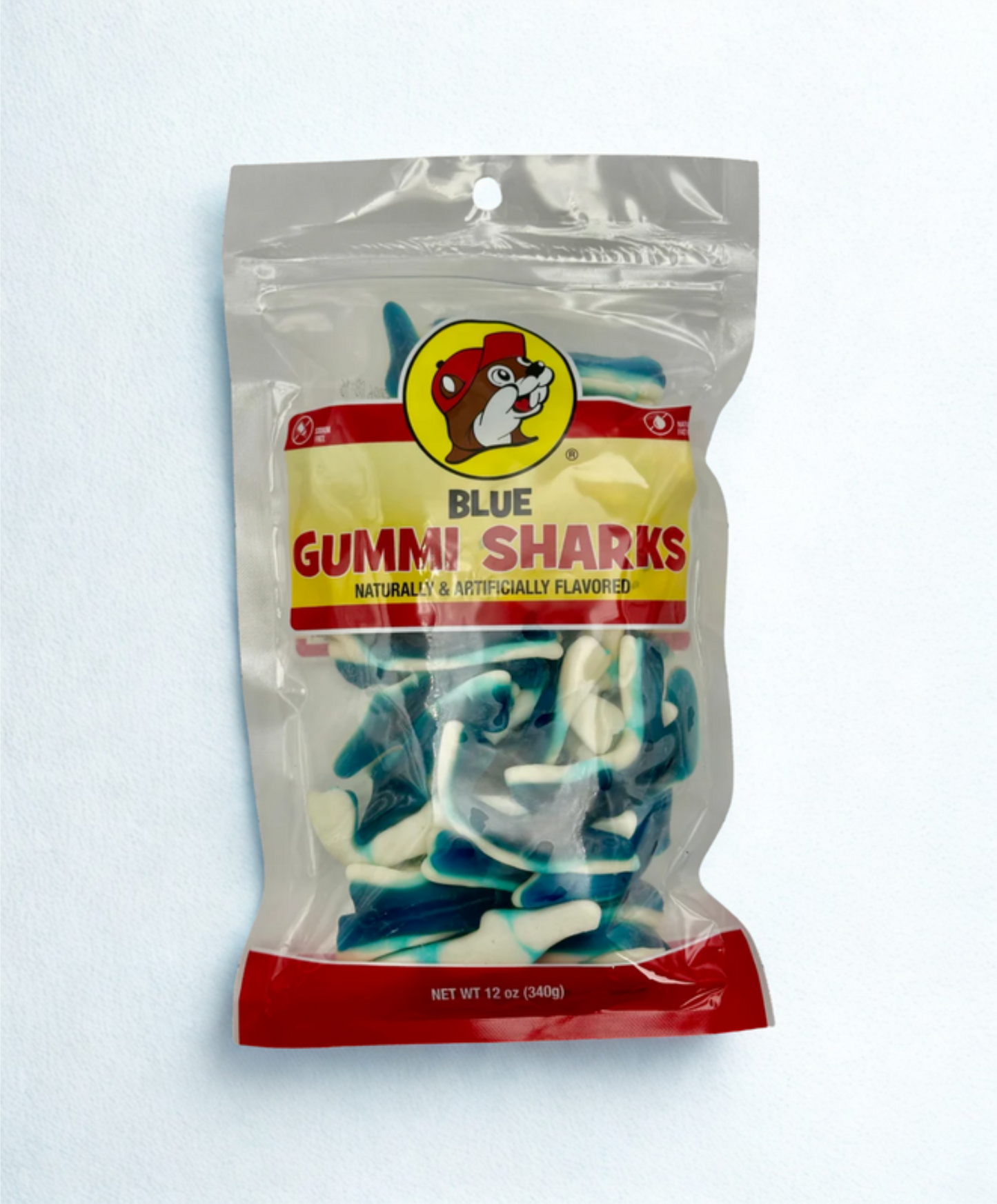Packaged blue gummy sharks on a wooden surface bucees