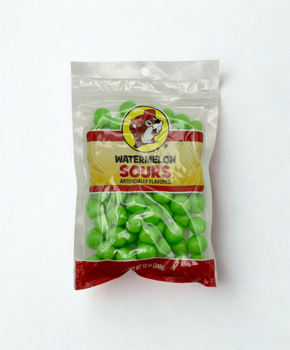 Packaged watermelon sour gummy candies on a wooden surface