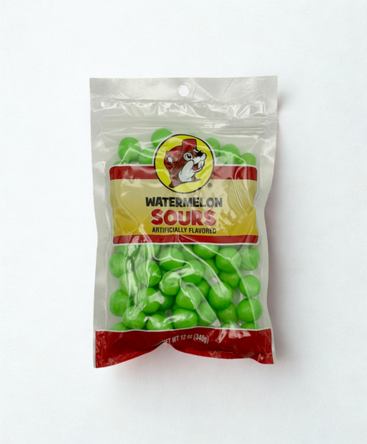 Packaged watermelon sour gummy candies on a wooden surface