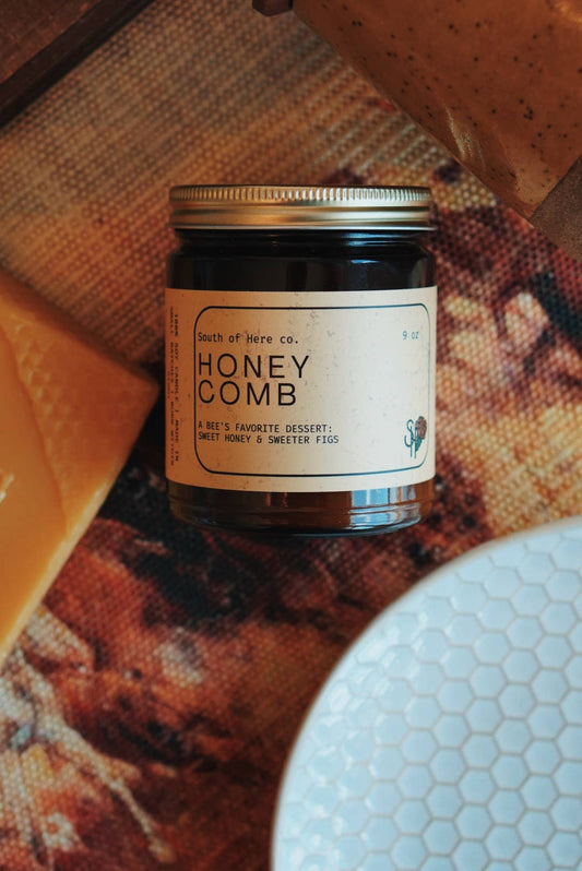 Candle labeled 'Honey Comb' on a textured surface with honeycomb pattern figs and honeycomb