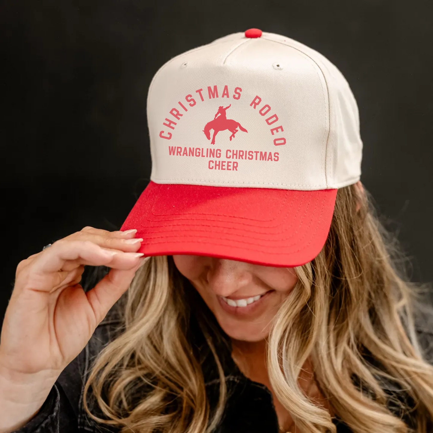 Person wearing a red and beige cap with Christmas rodeo design